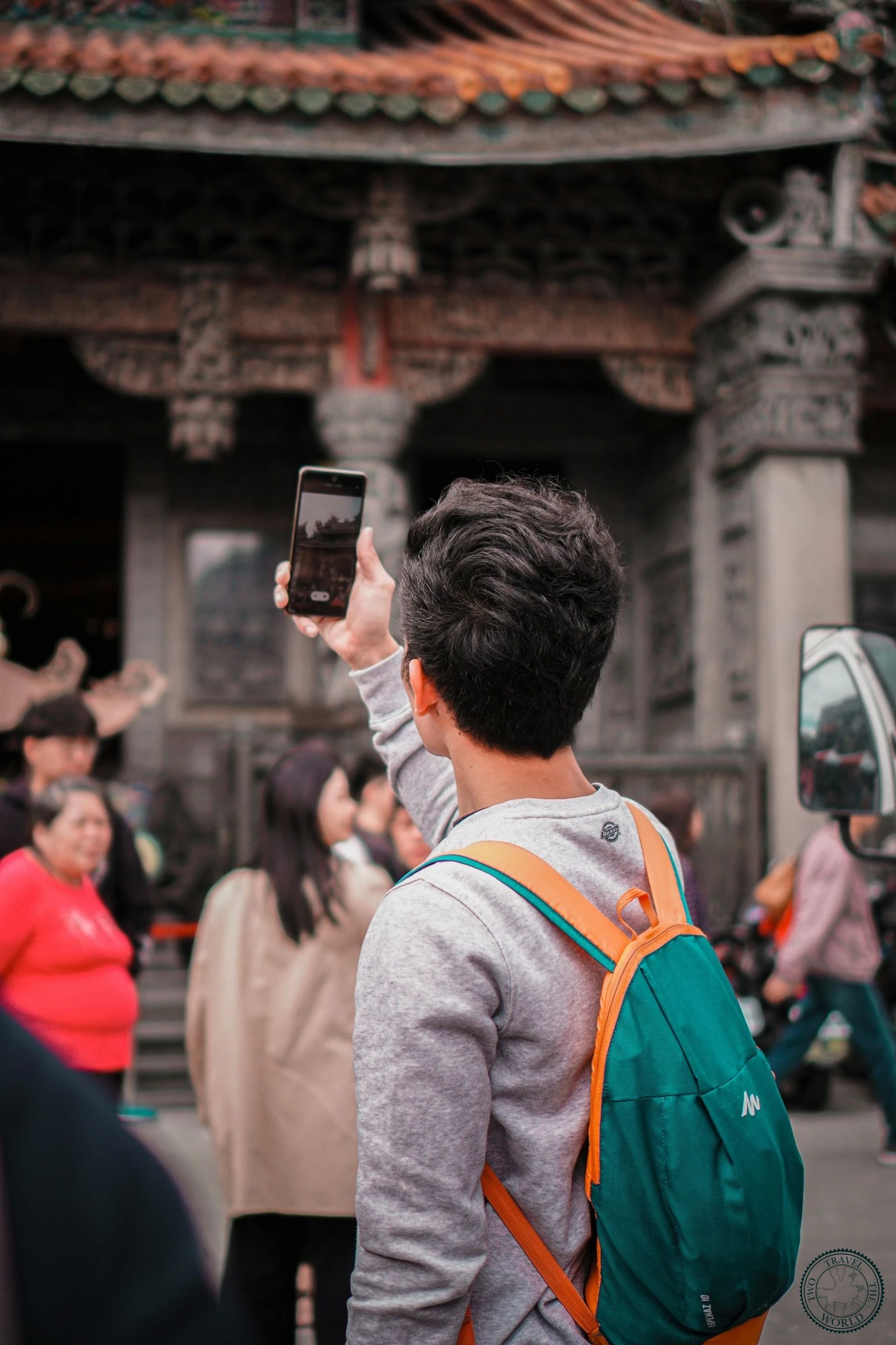 Traveller taking a photo with a smartphone at an Asian temple