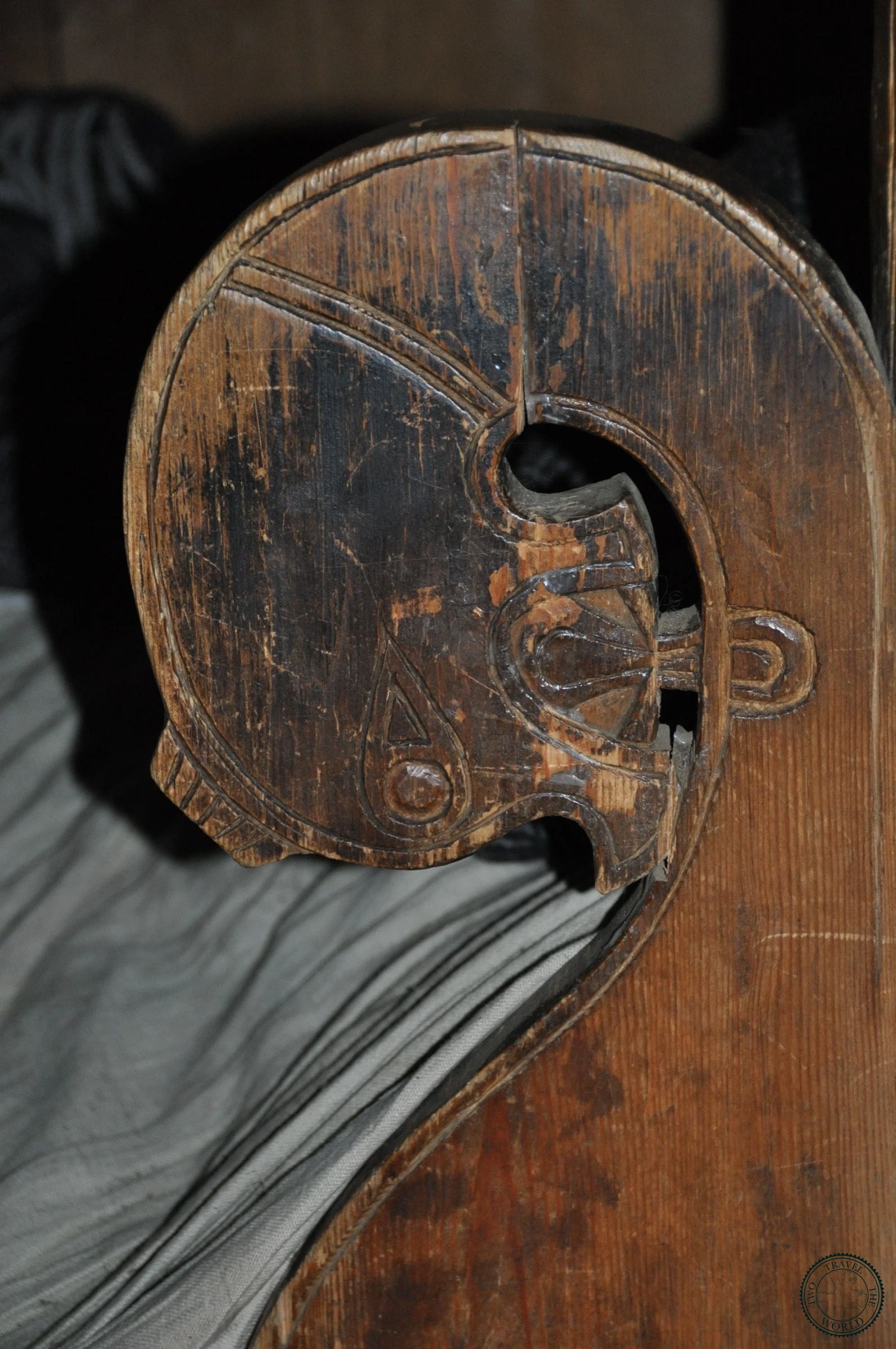 Carved wooden Viking-style animal head detail on a beam inside the longhouse