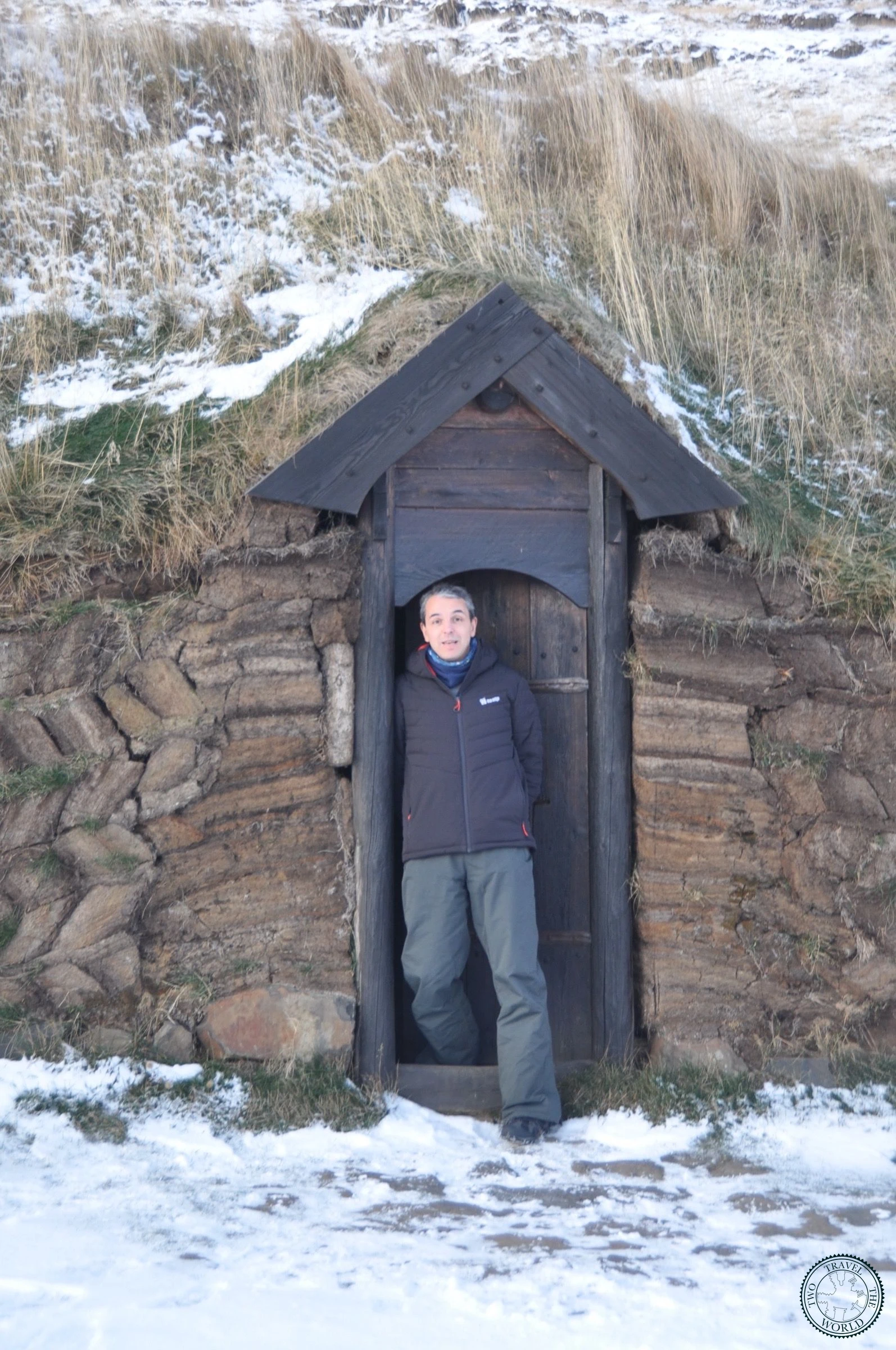Visitor beside the original excavation site ruins at Eiríksstaðir