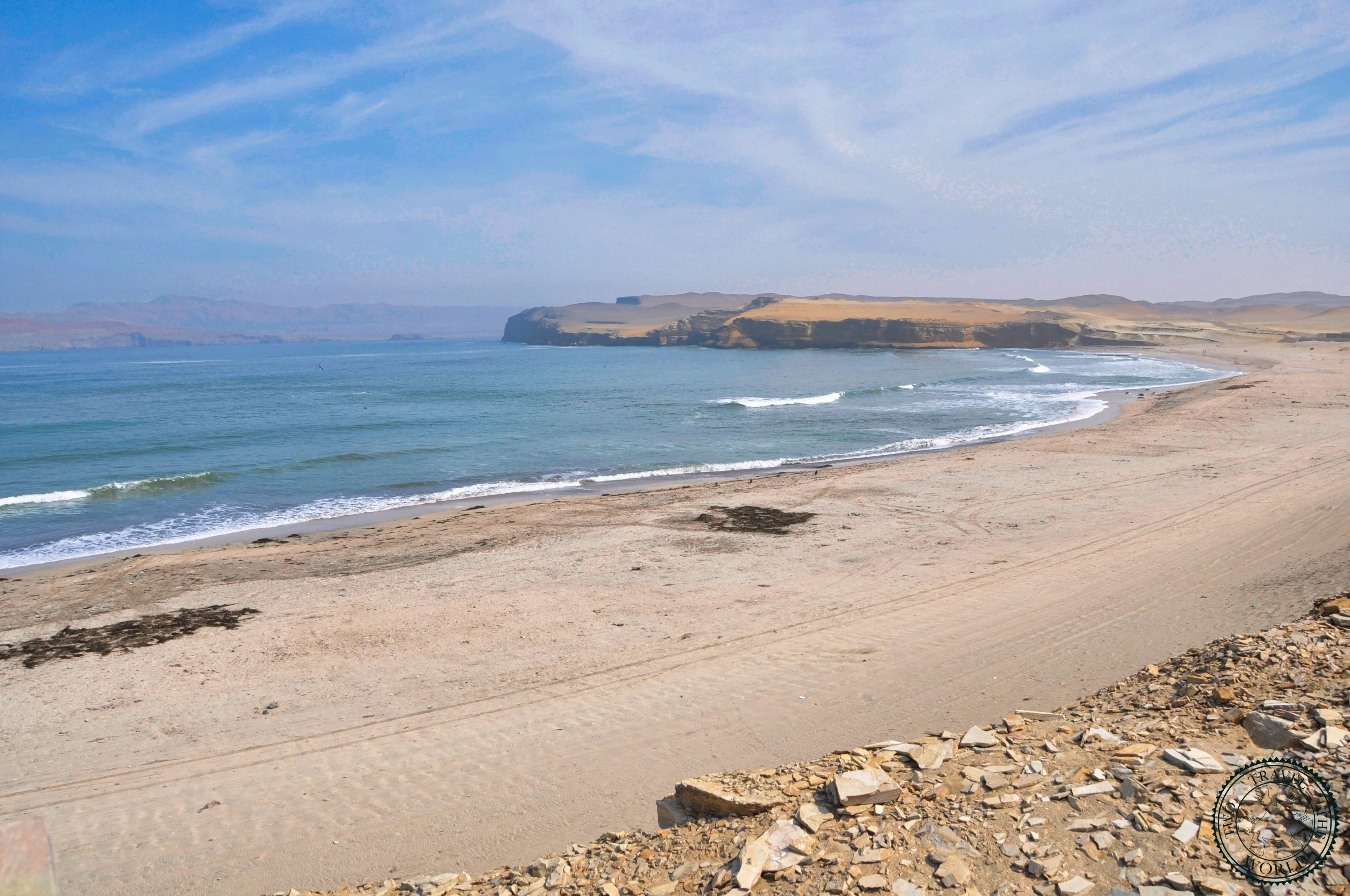 Steep coastal cliffs dropping into turquoise Pacific Ocean waters at Paracas