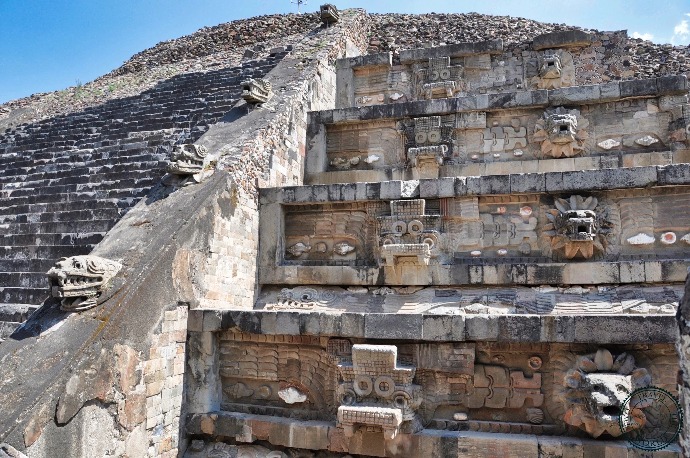 Detailed view of the carved stone serpent heads and feathered decorations on the Temple of the Feathered Serpent