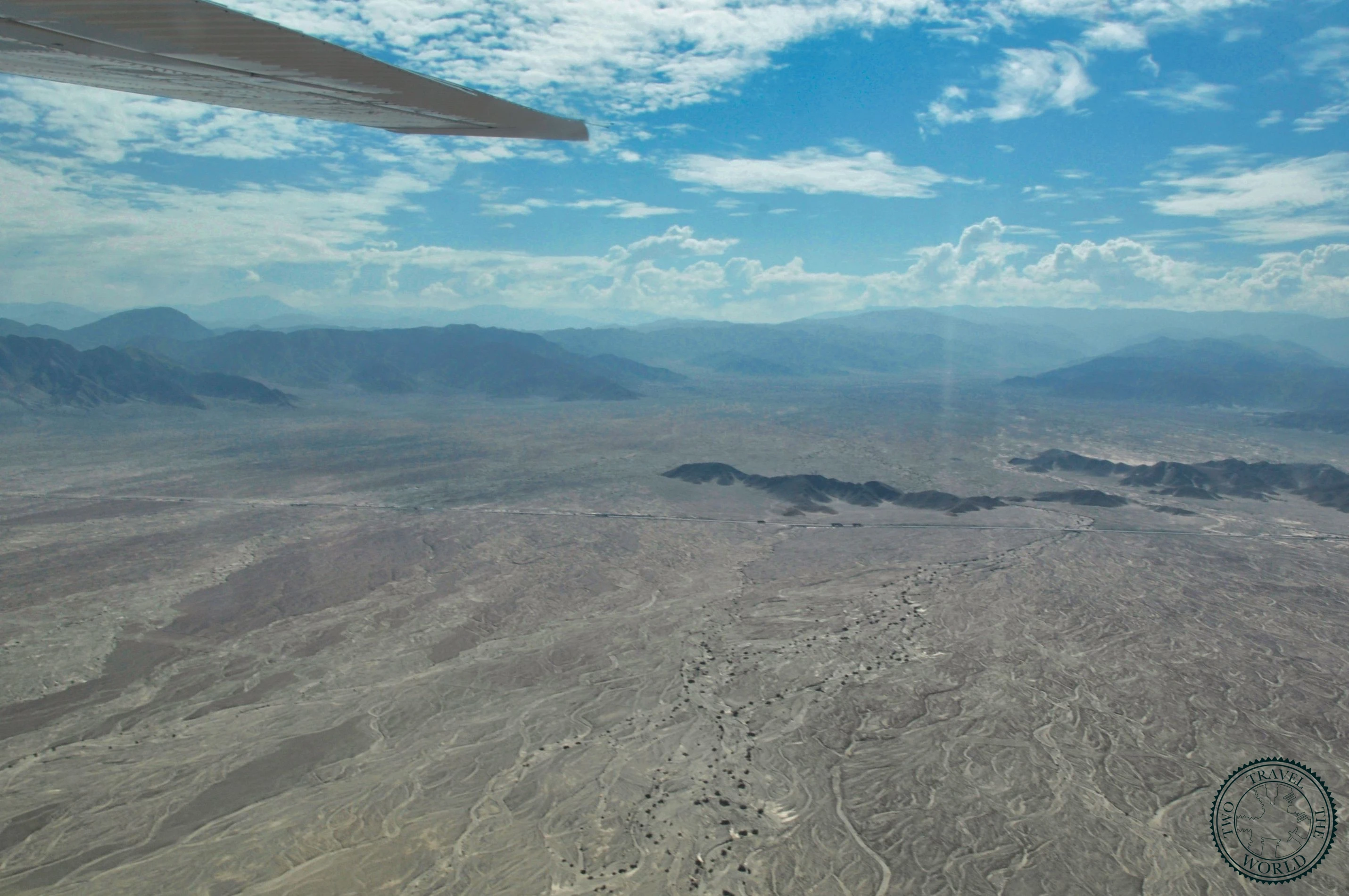 Aerial view of ancient geometric lines and shapes etched across the Nazca Desert plateau
