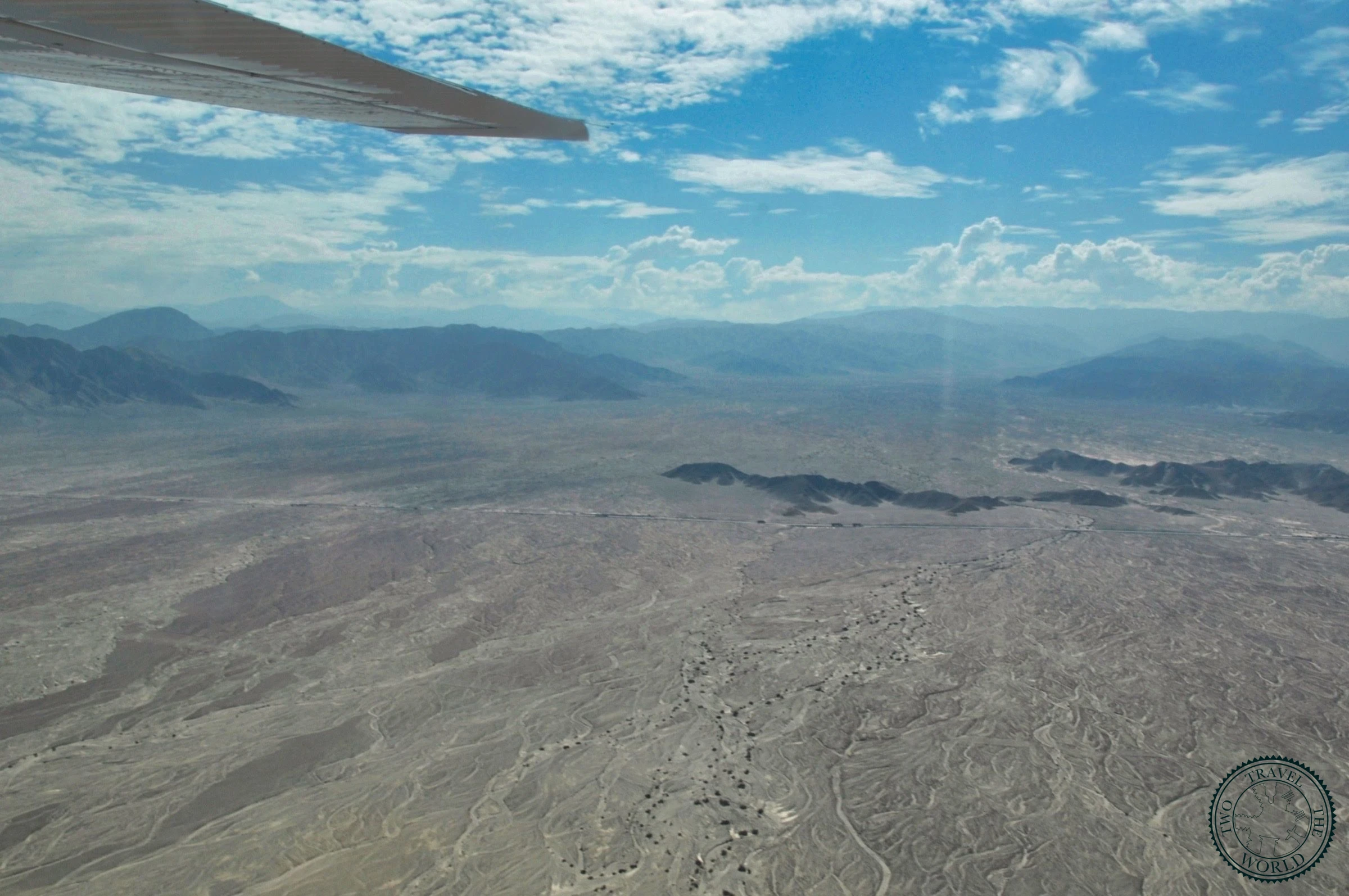 Aerial view of ancient geometric lines and shapes etched across the Nazca Desert plateau