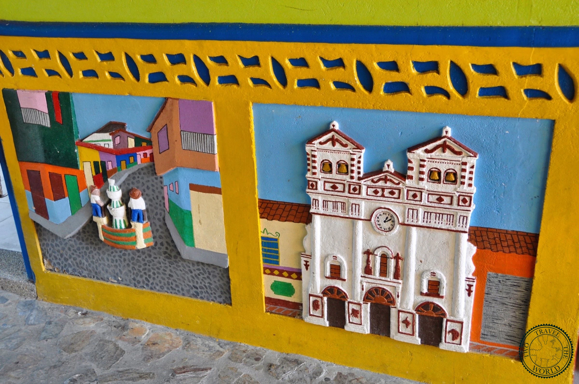 Vibrant street corner in Guatapé showcasing colorful painted facades and Zócalo art