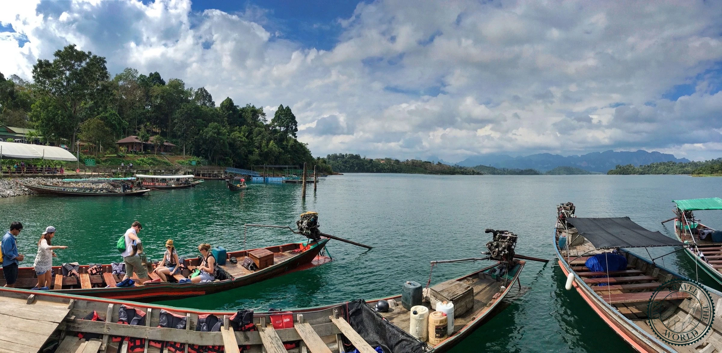 Longtail boat approaching towering limestone karsts on Cheow Lan Lake