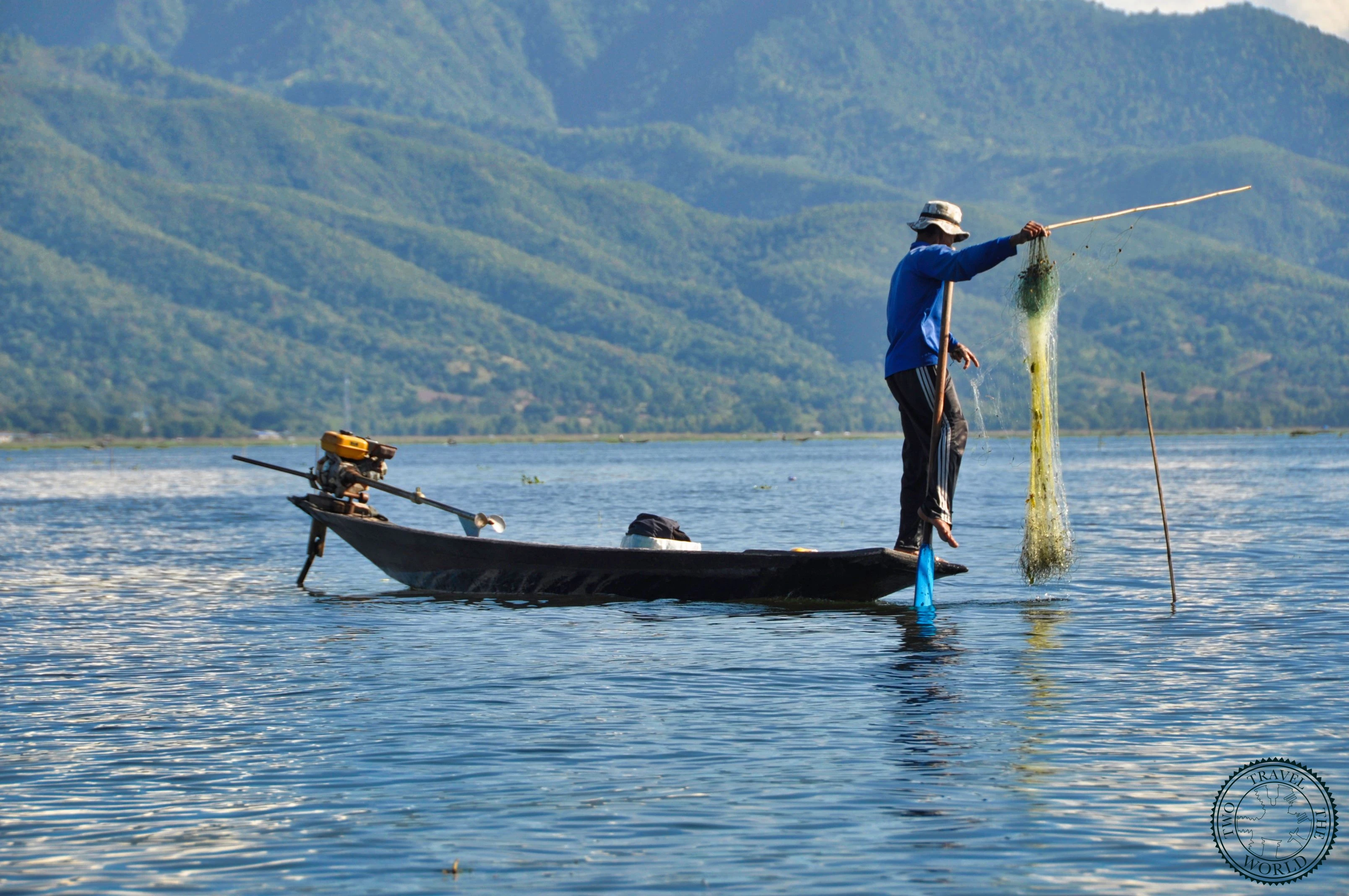 Traditional fishermen on Inle Lake with distinctive leg-rowing technique