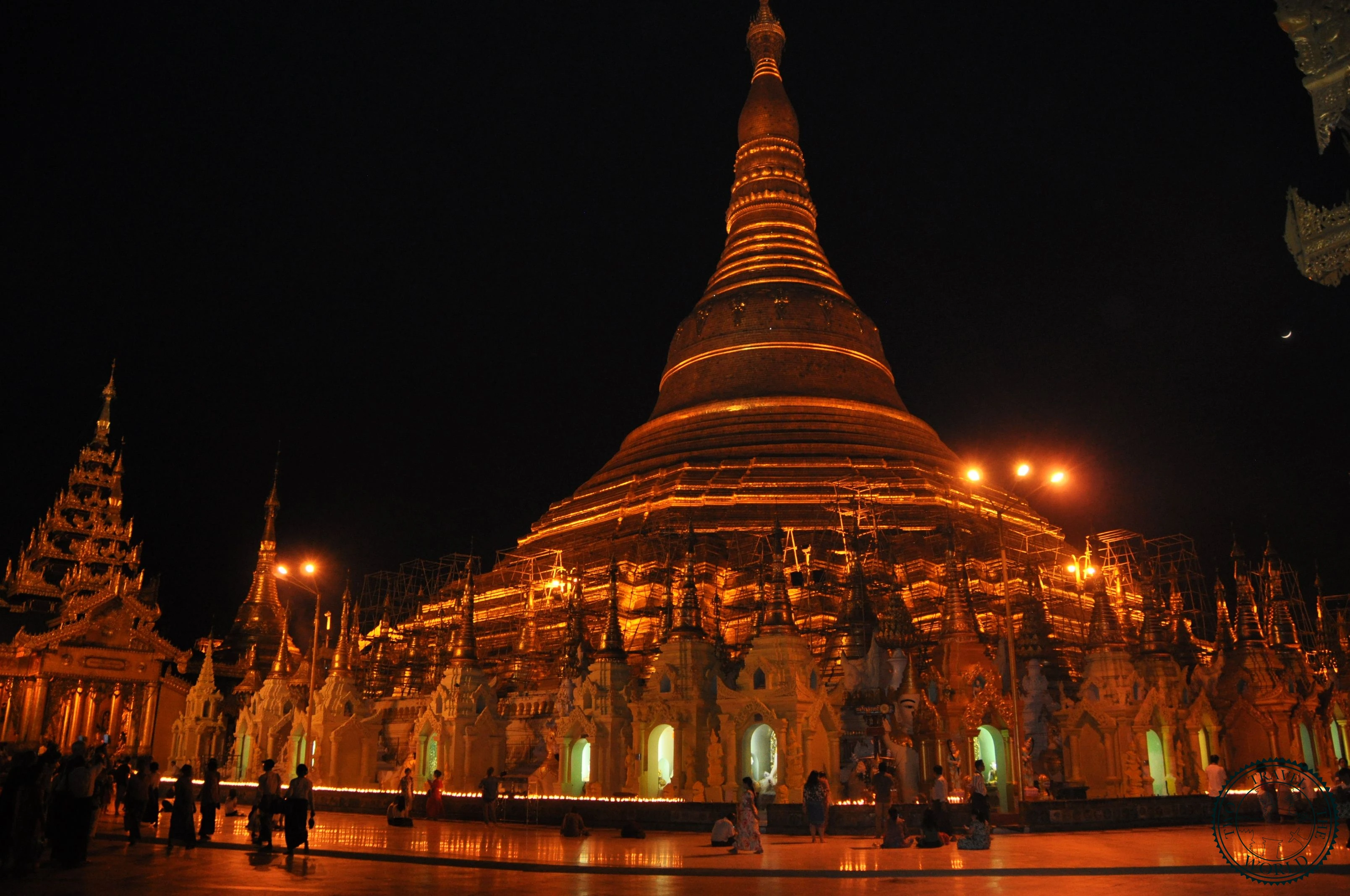 Devotees praying and offering flowers at Shwedagon Pagoda at sunset