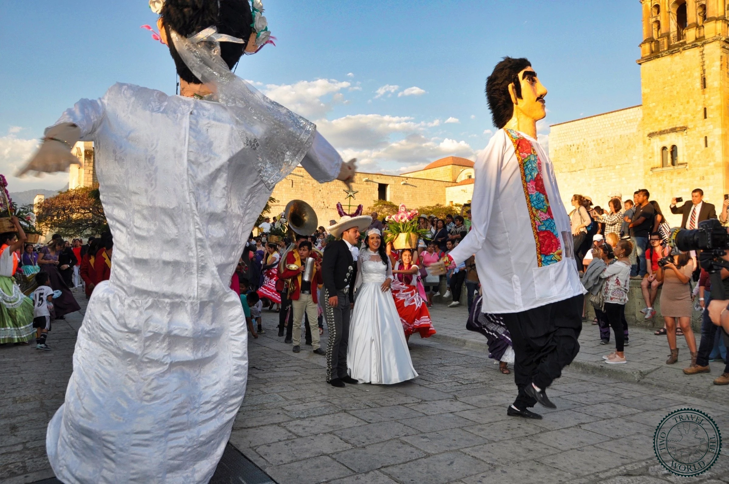 Elaborate Mexican wedding celebration outside Santo Domingo church in Oaxaca with colorful traditional decorations